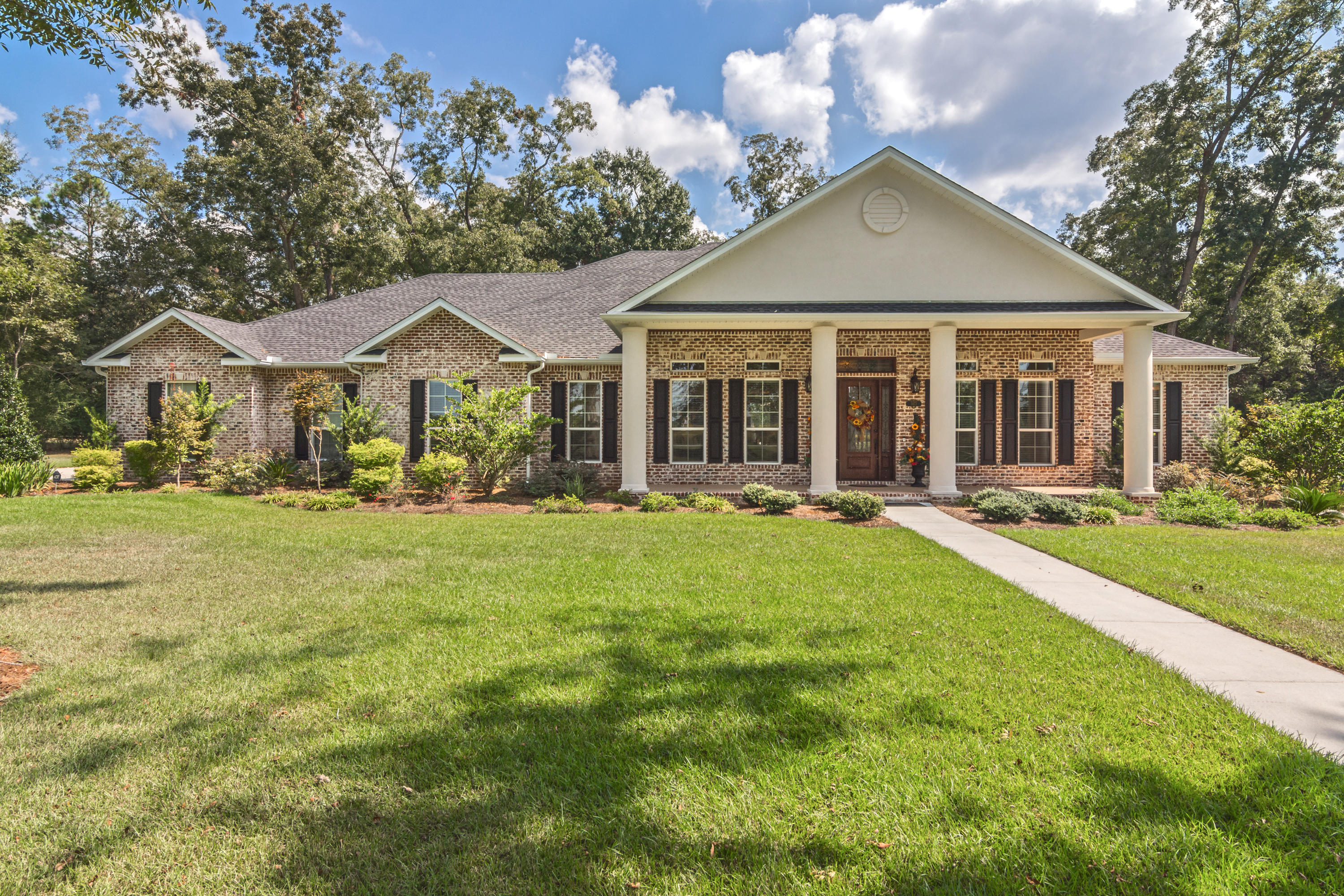 5973 Jack Stokes Road Baker, FL 32531 - Photo 3 of 61 a front view of a house with a garden