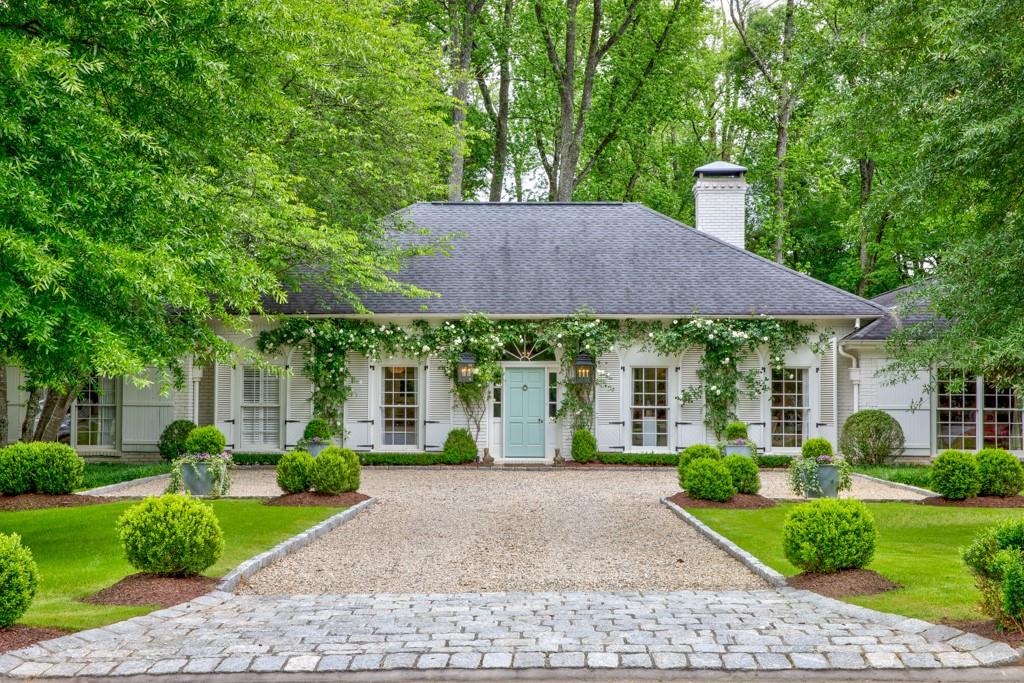 a view of house with garden and tall trees