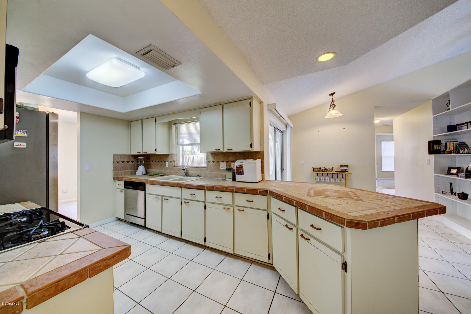 162 Crystal Lake Road Melbourne, FL 32901 - Photo 3 of 11 a kitchen with a sink dishwasher a stove and white cabinets with wooden floor
