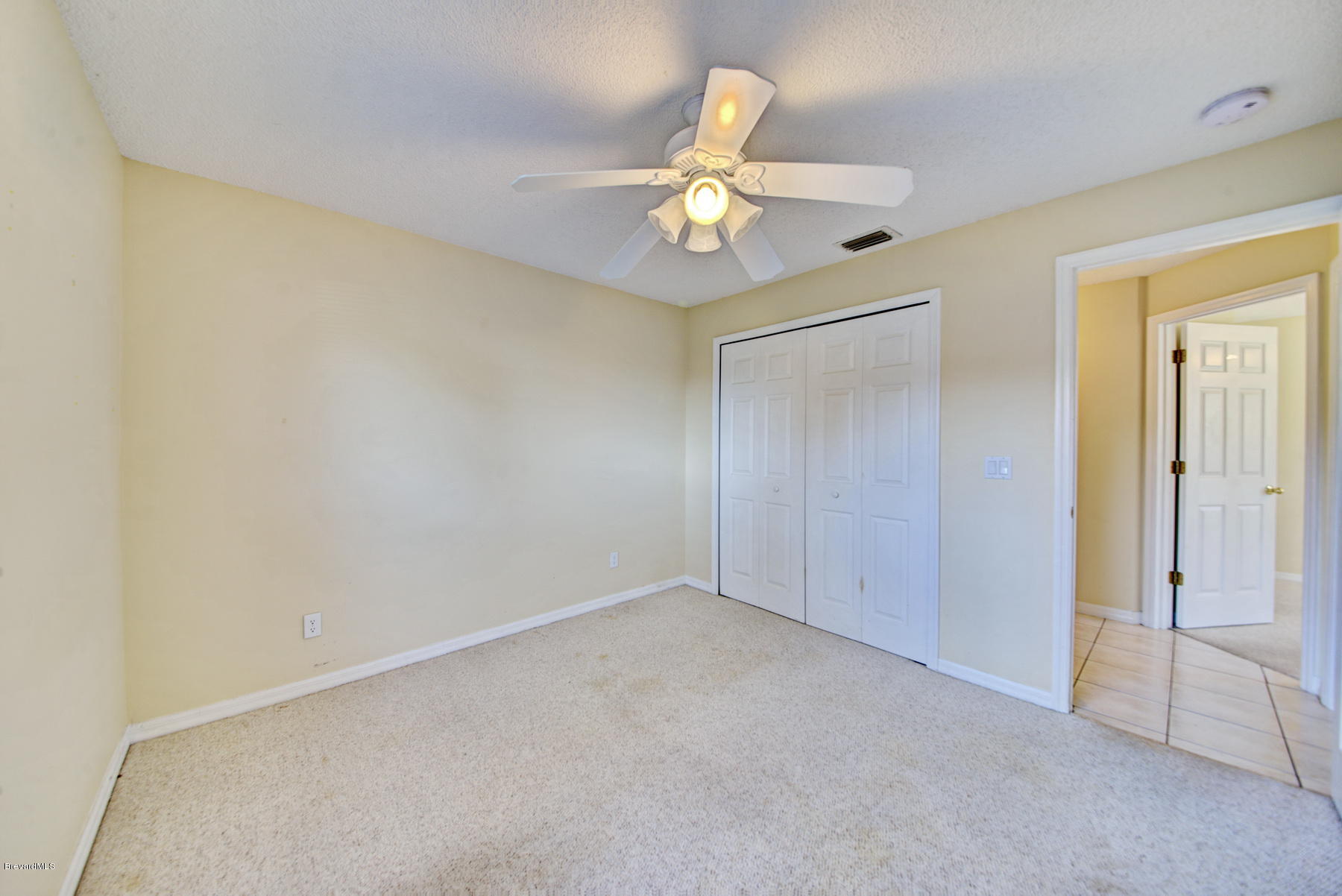 162 Crystal Lake Road Melbourne, FL 32901 - Photo 7 of 11 an empty room with a ceiling fan and a window