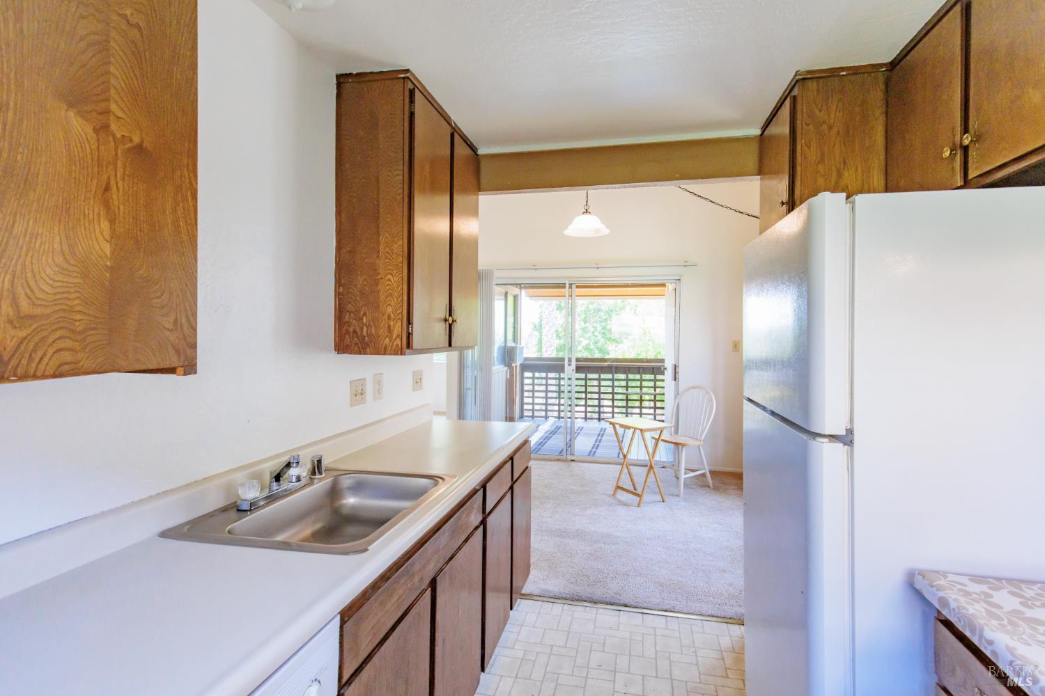 355 Parkview Terrace, Unit B2 Vallejo, CA 94589 - Photo 20 of 42 a kitchen with a sink a refrigerator and window
