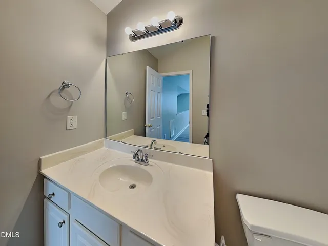a bathroom with a sink a toilet and mirror