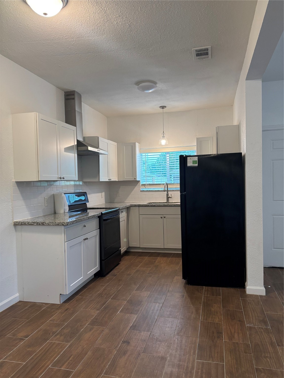 9834 Pelsey Street, Unit B Houston, TX 77029 - Photo 13 of 22 a kitchen with a sink a refrigerator and cabinets
