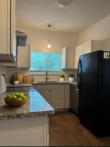 a kitchen with a sink a refrigerator and cabinets