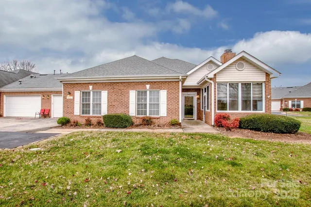 a front view of a house with a yard and potted plants
