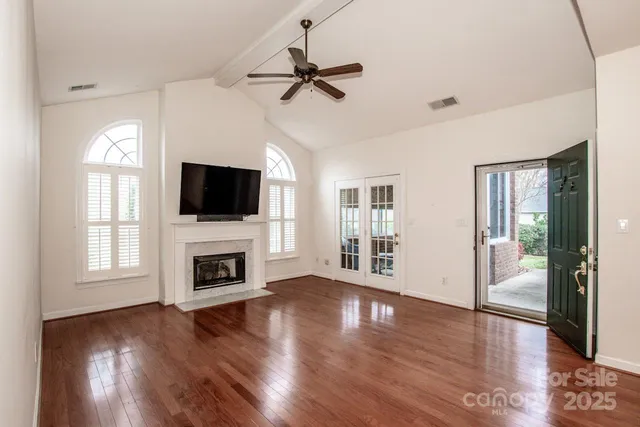 a view of a room with wooden floor a chandelier a wooden table and chairs