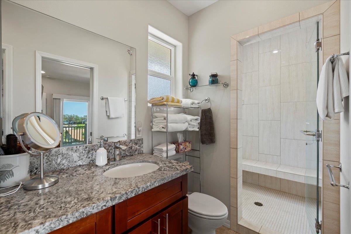 265 Kenolio Road Kihei, HI 96753 - Photo 12 of 50 a bathroom with a granite countertop sink toilet and shower