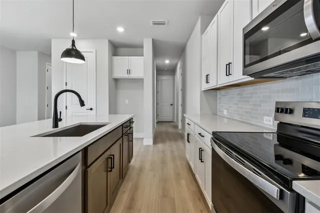 a kitchen with granite countertop a sink and a stove top oven