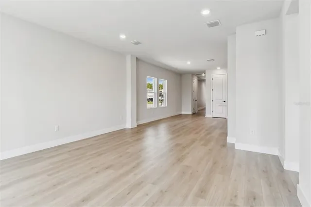 a bed sitting in a spacious bedroom next to a window