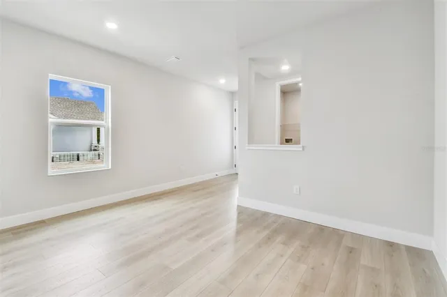 a kitchen with stainless steel appliances granite countertop a sink a stove a refrigerator cabinets and chairs