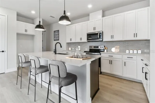 a kitchen with stainless steel appliances granite countertop a sink a stove and a refrigerator