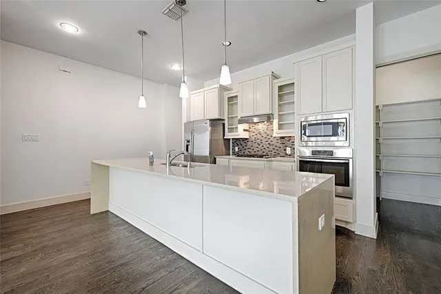 a view of a kitchen with wooden floor and a ceiling fan