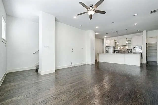 a kitchen with white cabinets and a refrigerator
