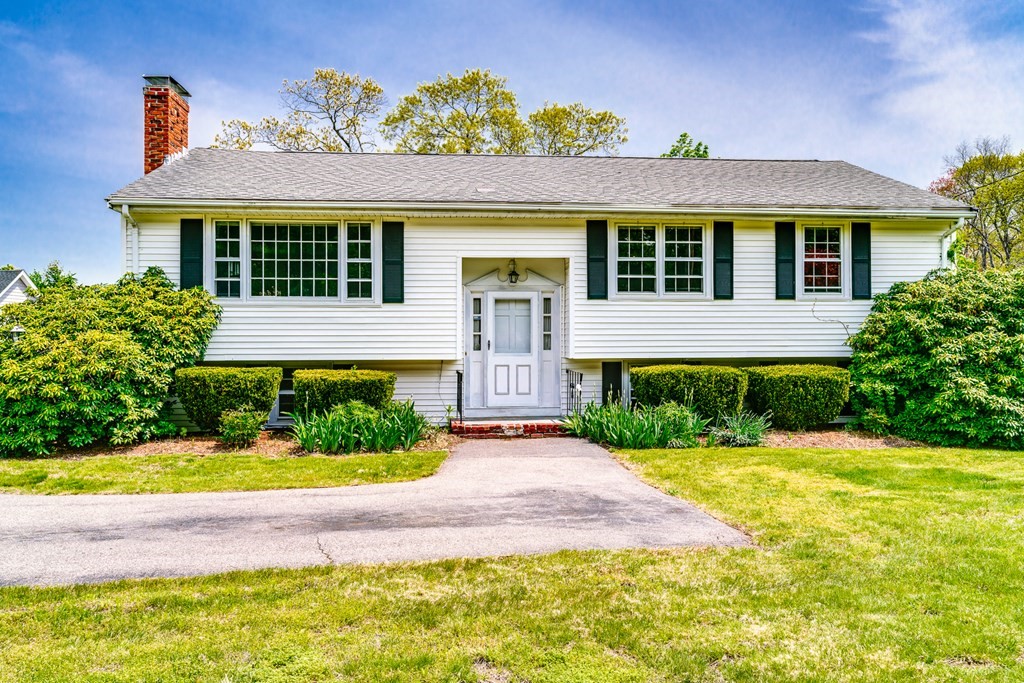 a front view of a house with a garden and plants