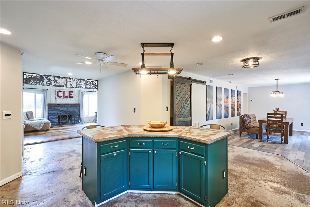 780 Bates Road Rocky River, OH 44116 - Photo 4 of 35 Central kitchen island with teal cabinetry and stone-look countertop, featuring a suspended light fixture