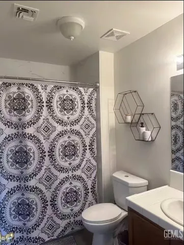 a white toilet sitting next to a shower curtain