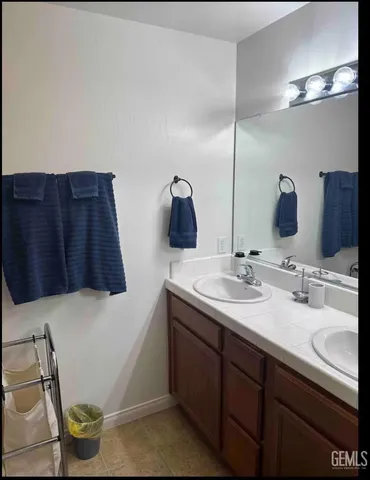 a bathroom with a double vanity sink and a mirror