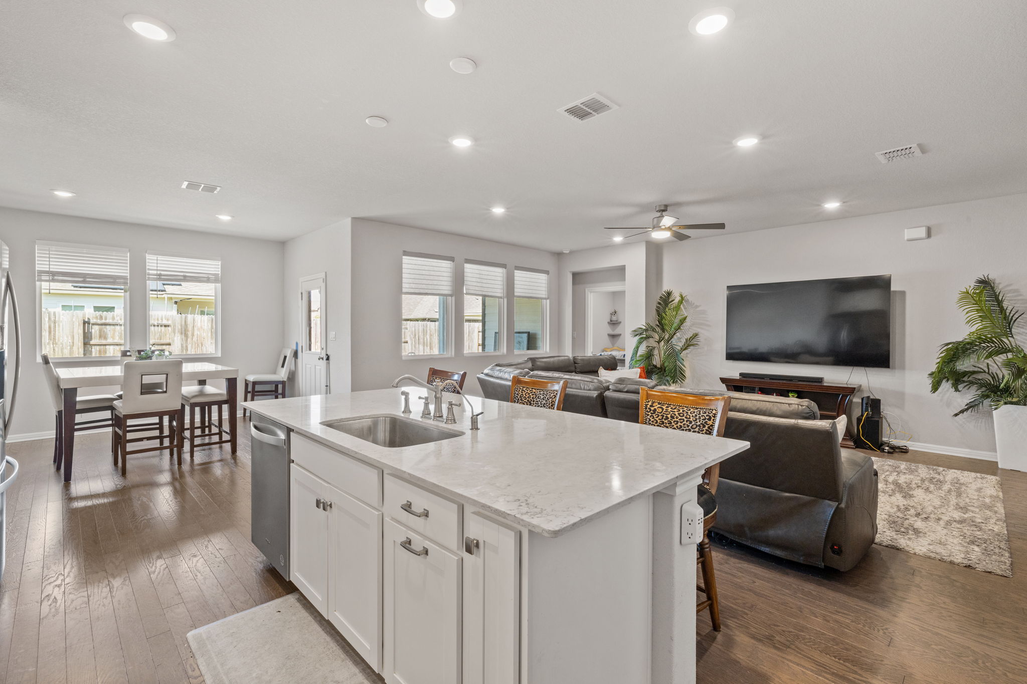 4009 Milano River Road Hutto, TX 78634 - Photo 39 of 39 Kitchen with open floor plan, light stone counters, dark wood finished floors, a center island with sink, and a breakfast bar area