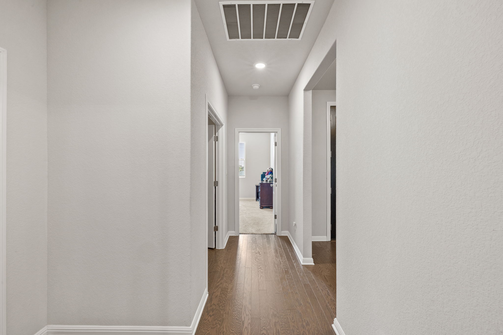 4009 Milano River Road Hutto, TX 78634 - Photo 22 of 39 Hall featuring dark wood-style flooring, recessed lighting, and a textured wall