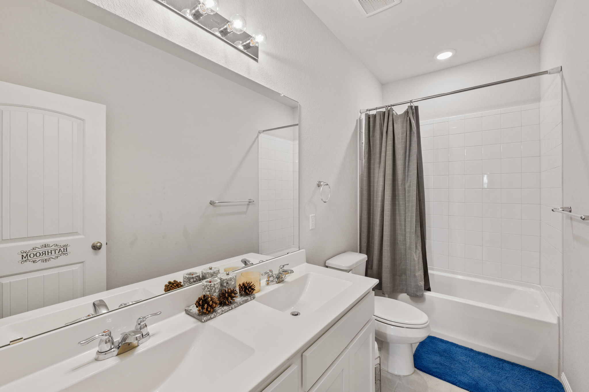 4009 Milano River Road Hutto, TX 78634 - Photo 24 of 39 Full bathroom with double vanity, shower / bath combination with curtain, and recessed lighting