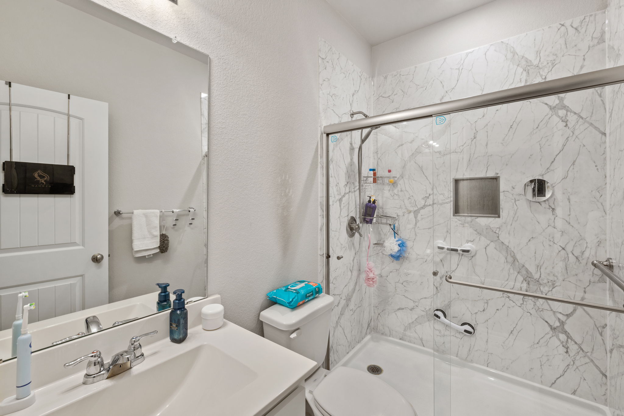 4009 Milano River Road Hutto, TX 78634 - Photo 29 of 39 Bathroom with vanity, a marble finish shower, and a textured wall