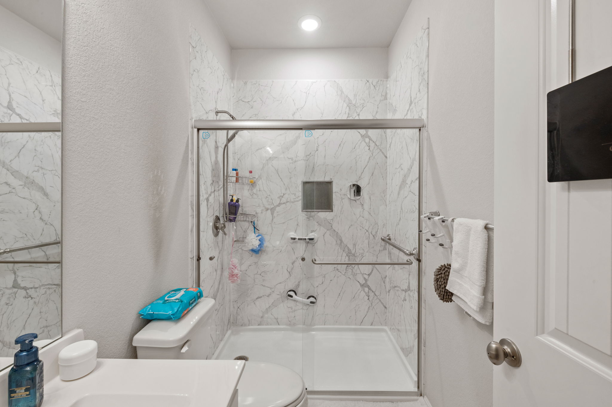 4009 Milano River Road Hutto, TX 78634 - Photo 30 of 39 Full bathroom featuring a textured wall, vanity, a marble finish shower, and recessed lighting
