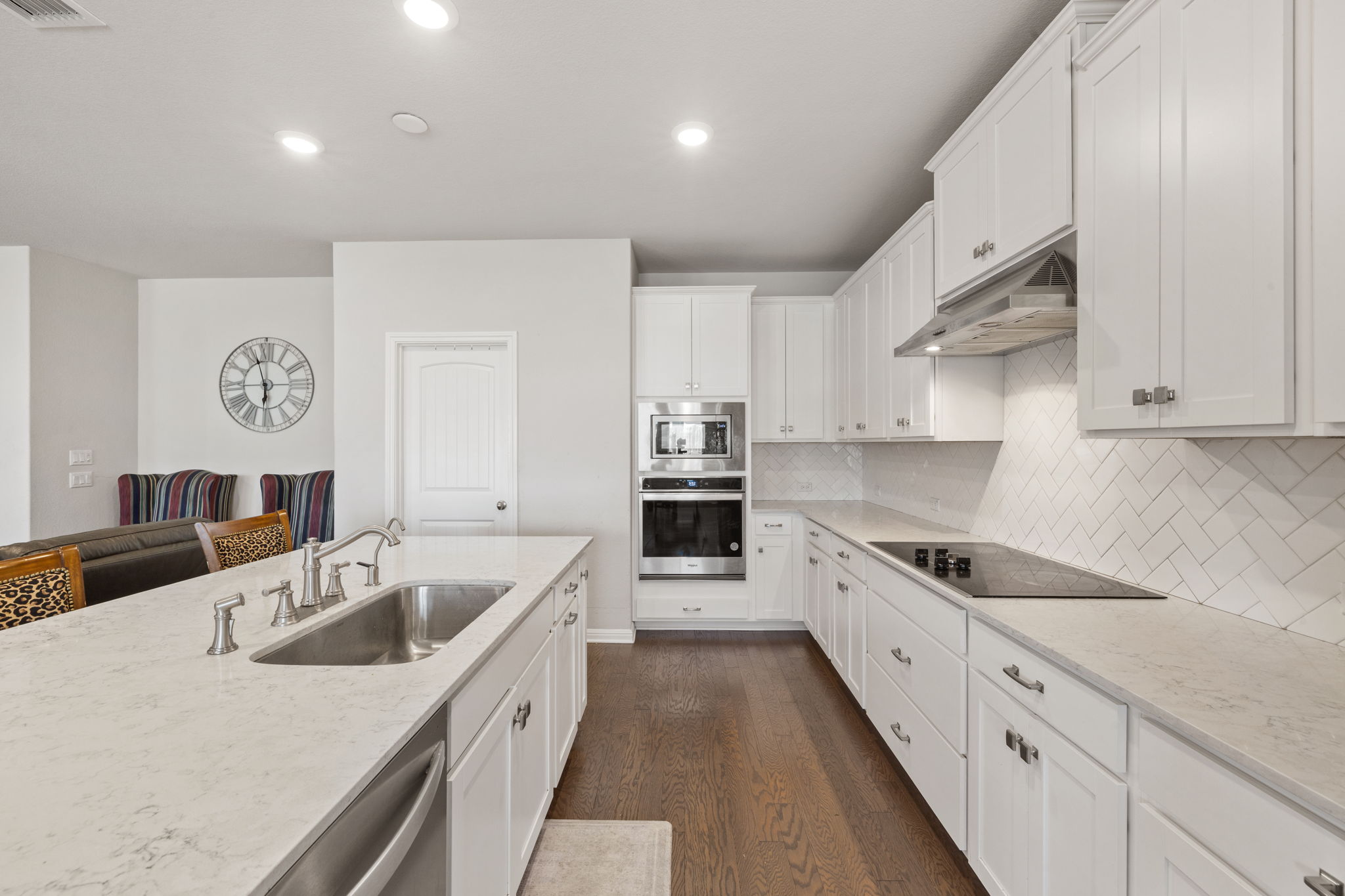 4009 Milano River Road Hutto, TX 78634 - Photo 9 of 39 Kitchen featuring white cabinets, stainless steel appliances, light stone countertops, dark wood-style flooring, and recessed lighting