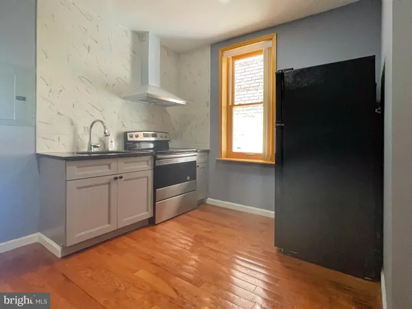 a kitchen with stainless steel appliances granite countertop a sink a stove a refrigerator and cabinets