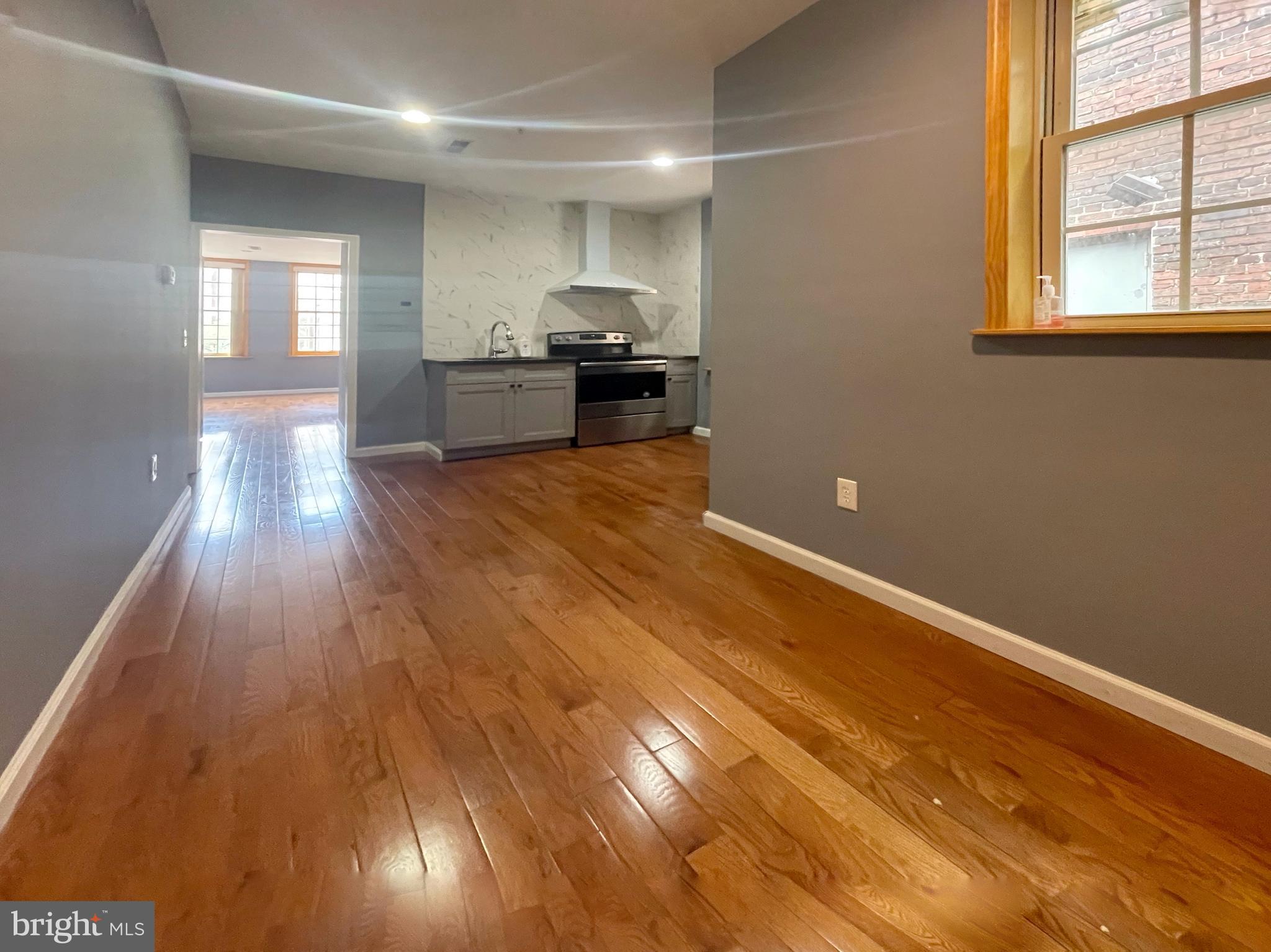 1316 Walnut Street, Unit 3R Philadelphia, PA 19107 - Photo 5 of 15 wooden floor in an empty room with a window