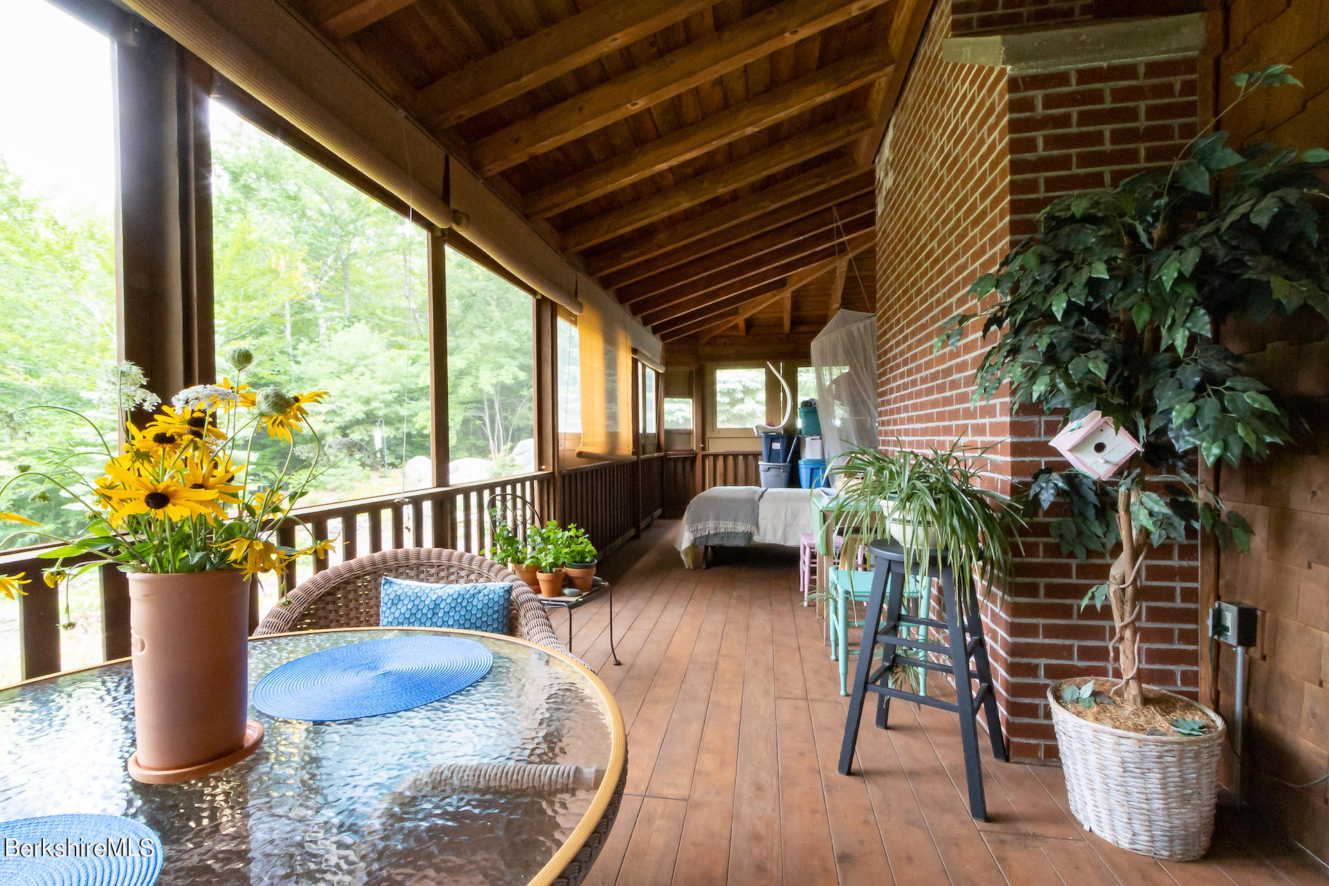 557 Captain Whitney Road Becket, MA 01223 - Photo 14 of 38 a view of a porch with furniture and a potted plant