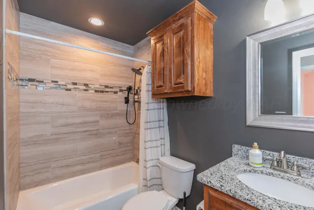 a view of a livingroom with a window and chandelier fan