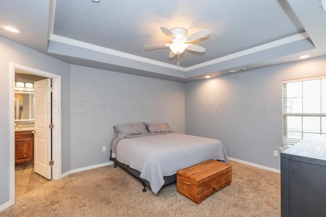 a bedroom with a bed and a flat tv screen on dresser