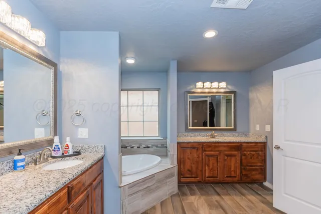 a bathroom with a tub a sink and a window