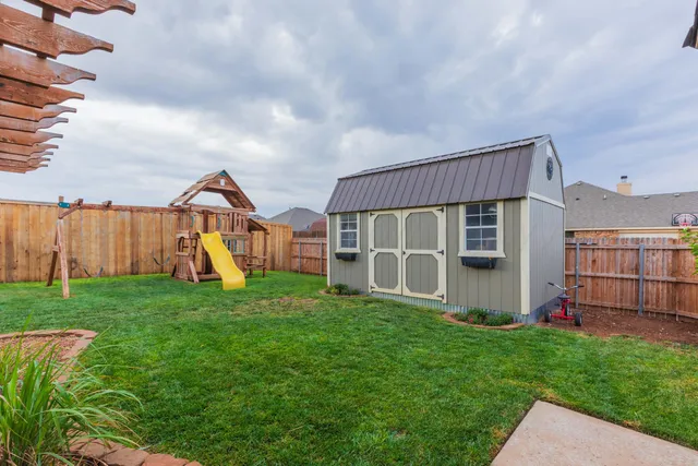 a view of a house with a yard and potted plants