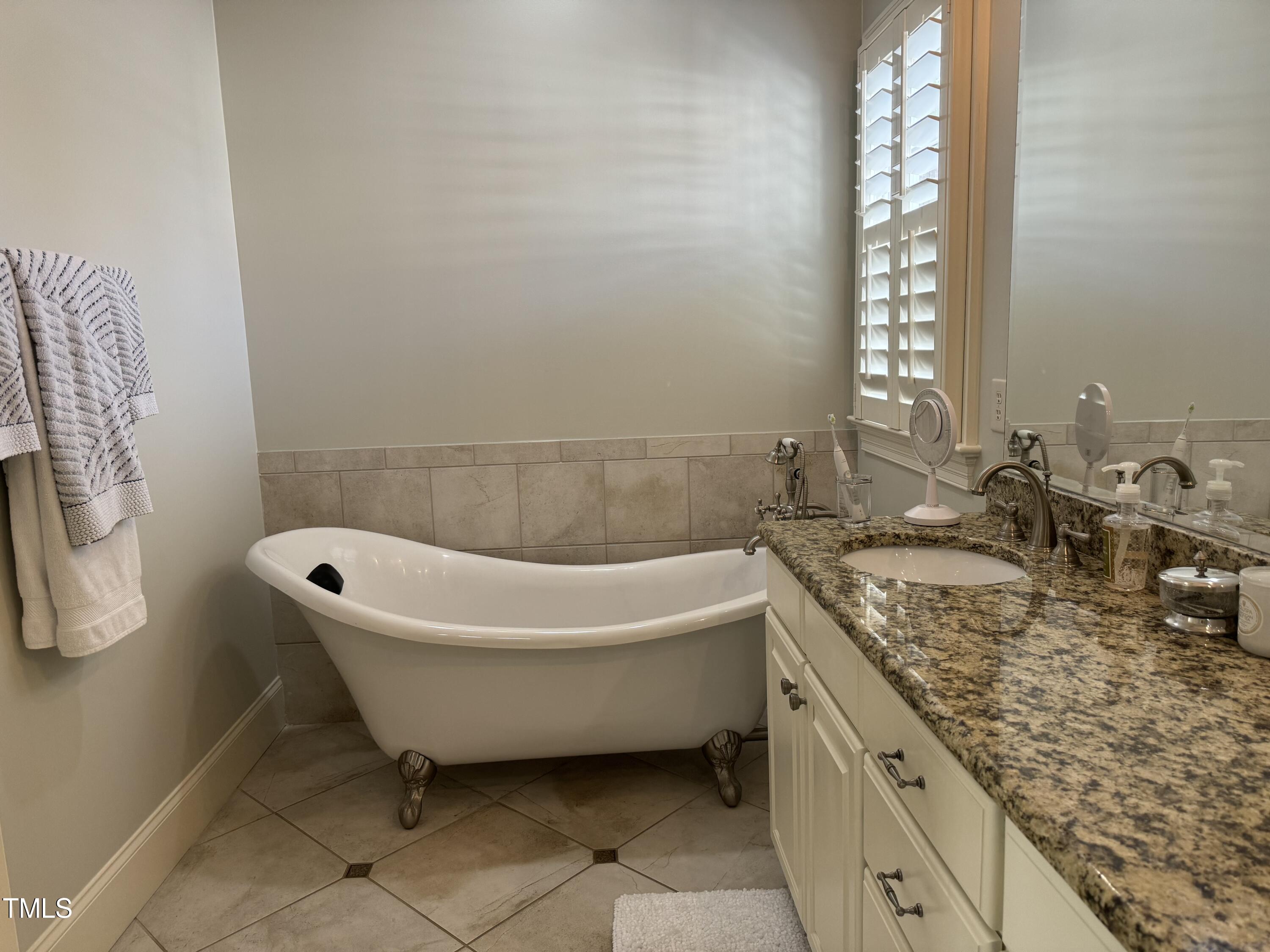 535 Guilford Circle Raleigh, NC 27608 - Photo 19 of 30 a bathroom with a granite countertop sink and a bathtub