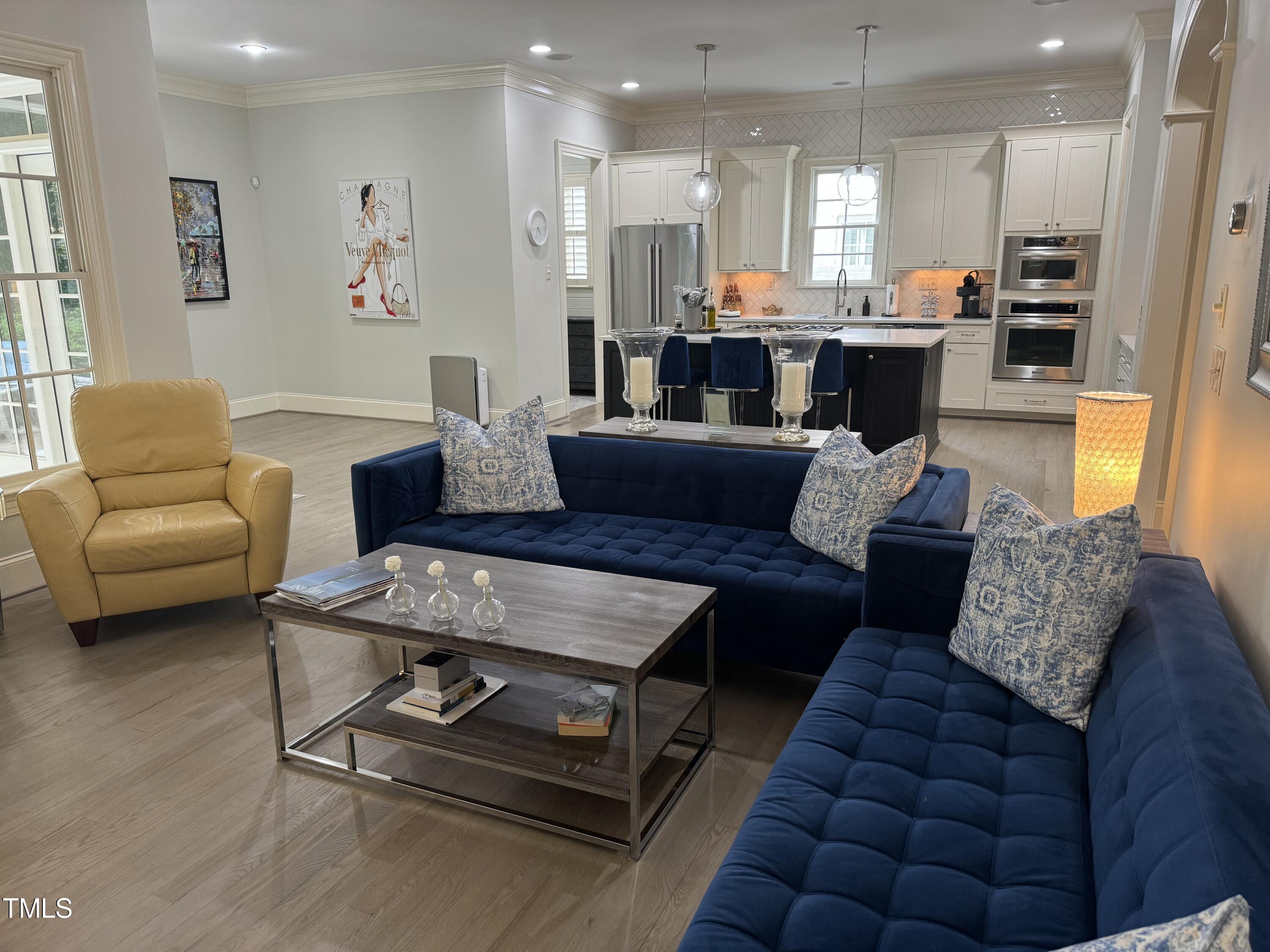 535 Guilford Circle Raleigh, NC 27608 - Photo 7 of 30 a living room with furniture and a dining table with wooden floor