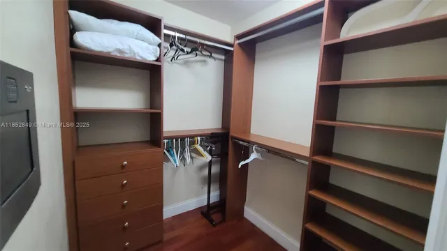 a view of walk in closet with clothes and shoes