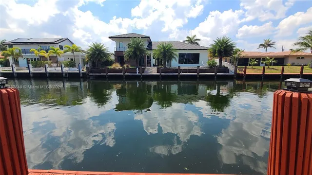 a view of a house with pool and plants
