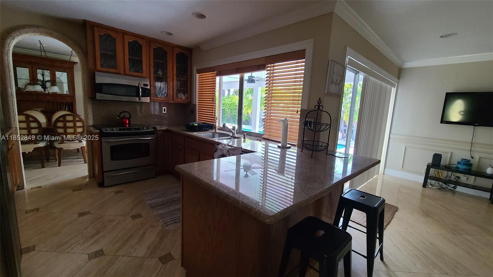 4211 Northeast 25th Avenue Lighthouse Point, FL 33064 - Photo 6 of 29 a kitchen with granite countertop a stove and cabinets
