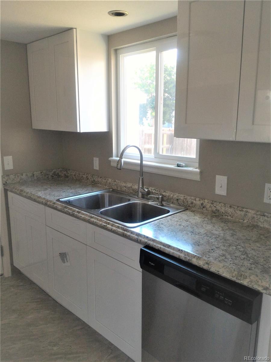 1689 Ensenada Way Aurora, CO 80011 - Photo 12 of 15 a kitchen with granite countertop white cabinets and a sink