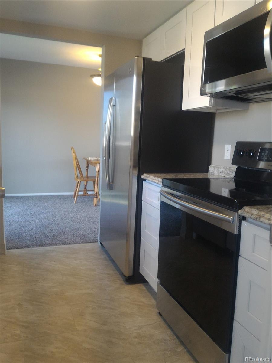 1689 Ensenada Way Aurora, CO 80011 - Photo 13 of 15 a kitchen with a refrigerator and a stove top oven