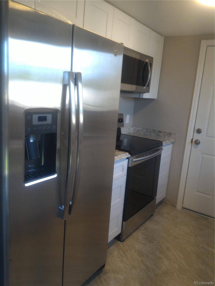 1689 Ensenada Way Aurora, CO 80011 - Photo 15 of 15 a kitchen with refrigerator and microwave