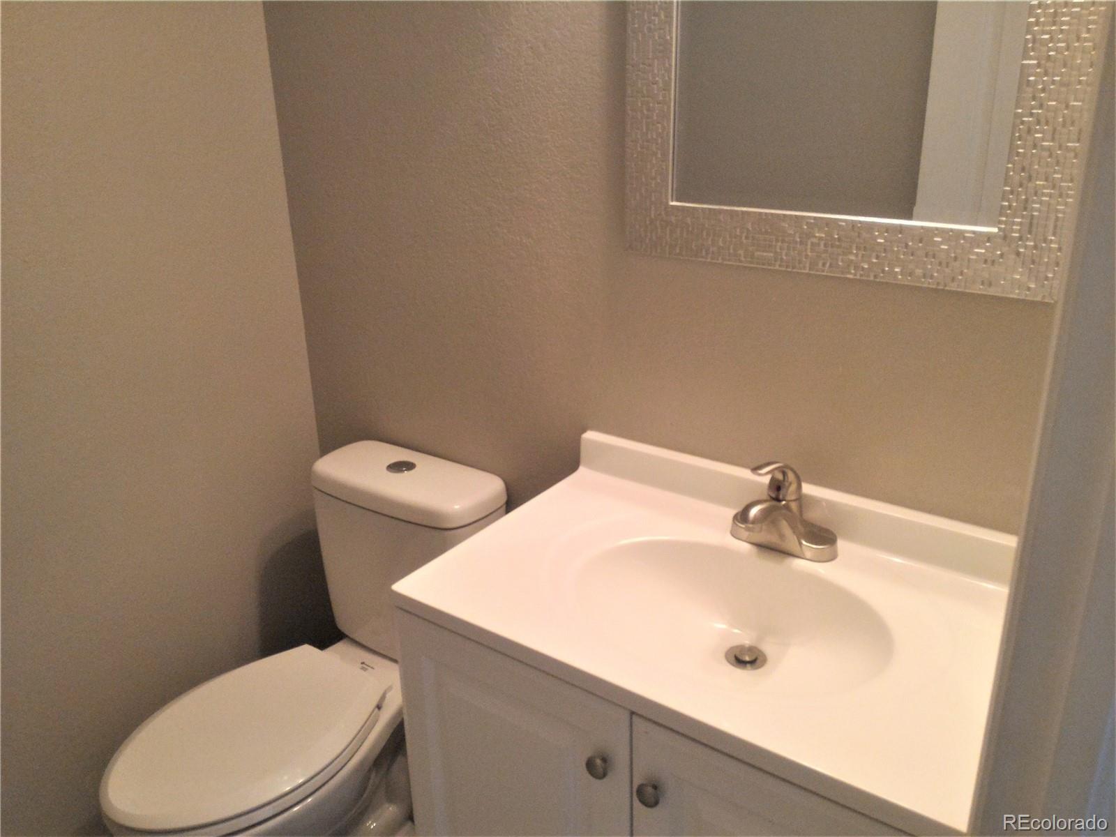 1689 Ensenada Way Aurora, CO 80011 - Photo 9 of 15 a white toilet sitting next to a bathroom sink