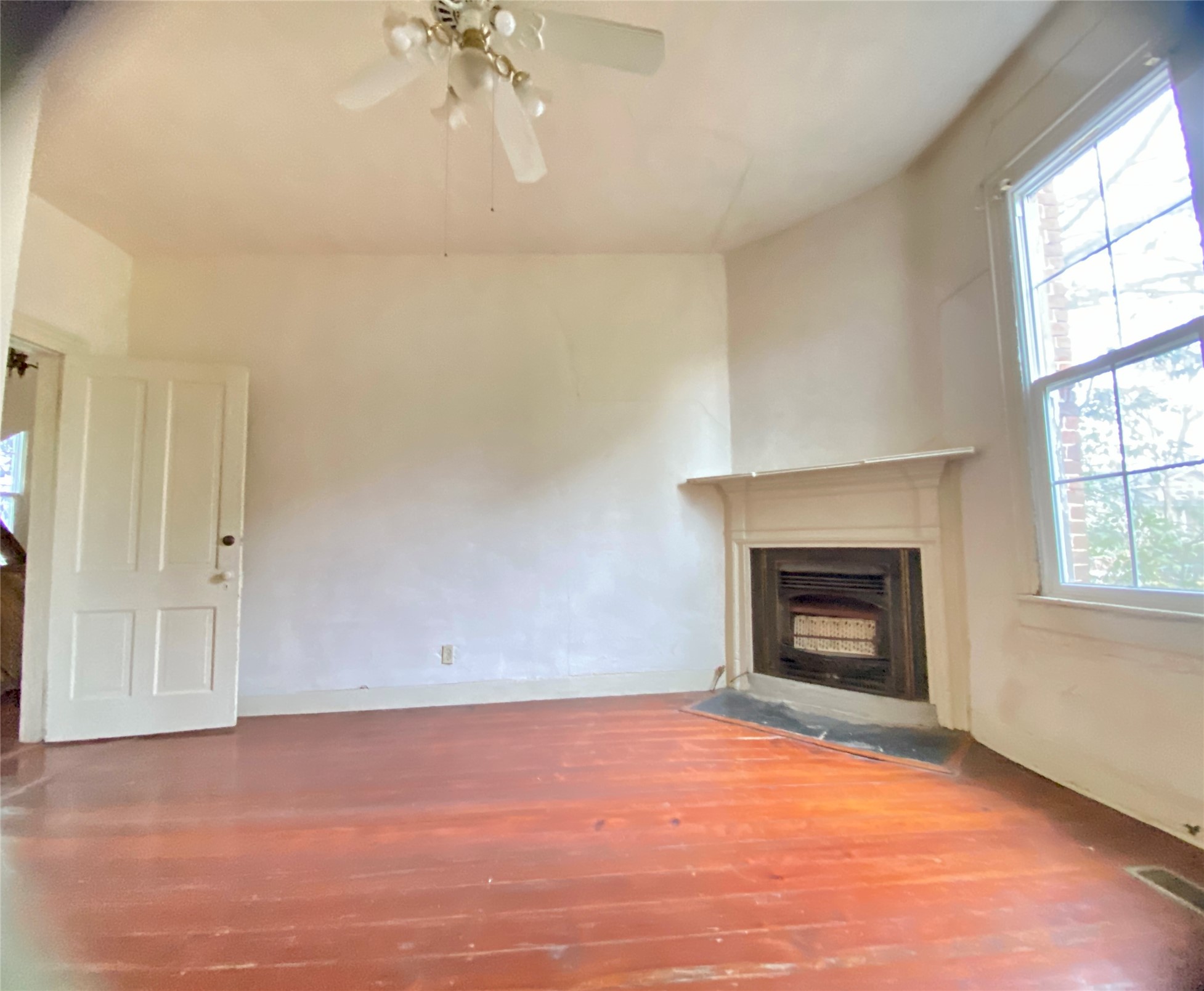 108 West Liberty Street Washington, GA 30673 - Photo 11 of 24 an empty room with windows and fireplace