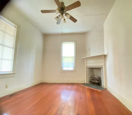 an empty room with windows and fireplace