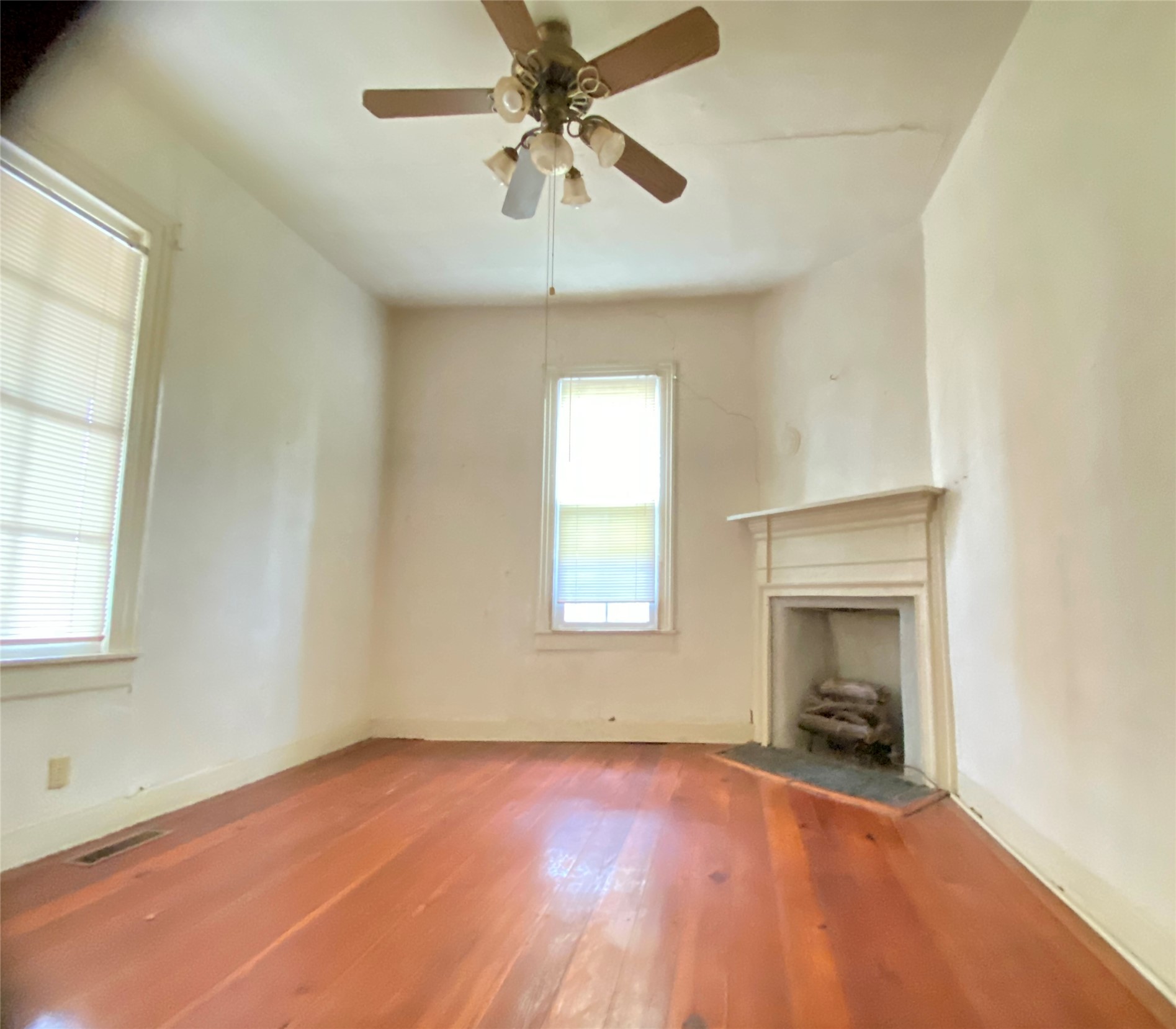 108 West Liberty Street Washington, GA 30673 - Photo 10 of 24 an empty room with chandelier fan and windows