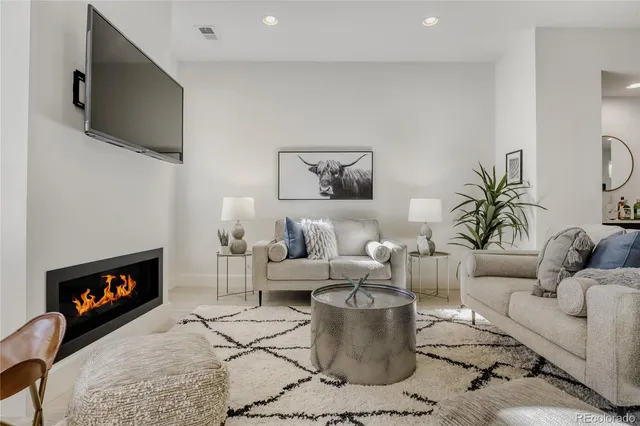 a living room with furniture a flat screen tv and a fireplace