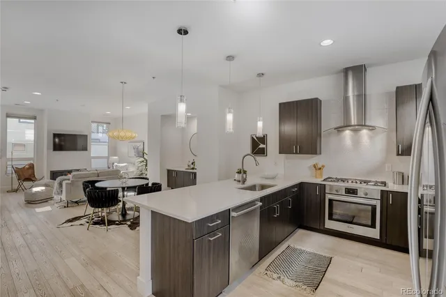 a kitchen with stainless steel appliances kitchen island granite countertop a sink a stove and a refrigerator