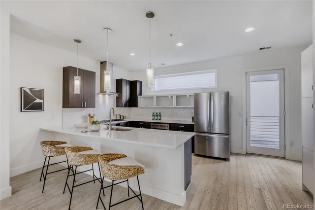 a kitchen with stainless steel appliances a refrigerator and a stove top oven