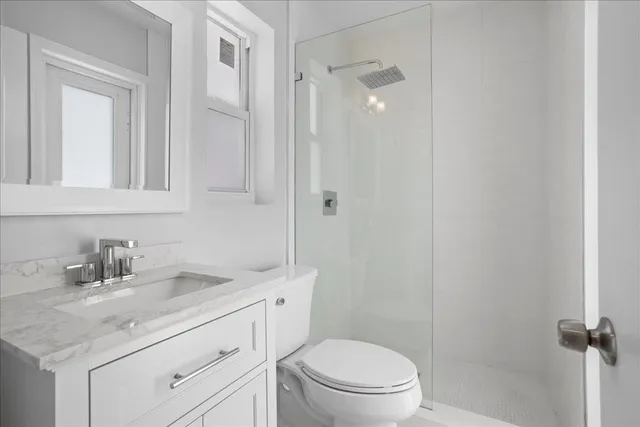 a bathroom with a sink toilet vanity and shower